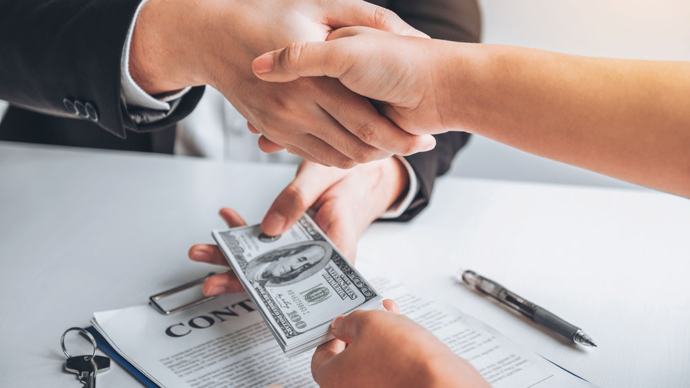 Person accepting loan money after home inspection services were completed.